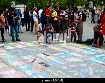 London, UK. 17. Mai 2014. Mann auf dem Trafalgar Square zeichnen alle Flaggen der Welt. Menschen verlassen konnte einige Münzen auf die Flagge ihres Landes. Touristen und Londoner wurden überall gesammelt, während der Mann Credit zeichnete: Giulia Fiori/Alamy Live News Stockfoto