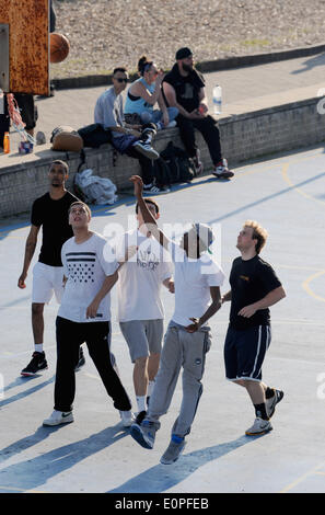 Brighton Sussex UK 18. Mai 2014 - junge Männer spielen Basketball auf den Außenplätzen auf Brighton Seafront am Ende eines Wochenendes des heißen Wetters in ganz Großbritannien Stockfoto