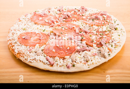 Eine gefrorene Peperoni-Pizza auf ein Holz Schneidebrett Stockfoto