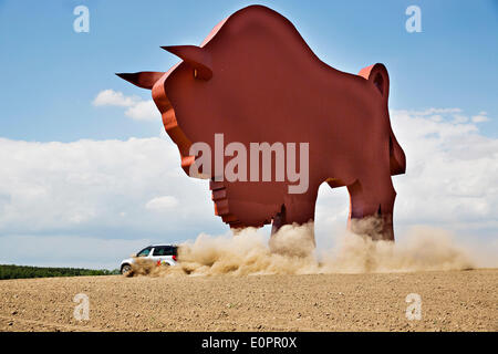 SUV mit Journalisten durchfährt ein Feld, eine riesige Statue des belarussischen Nationalsymbol, Wisente, auf einer Autobahn, Minsk, Belarus, auf Samstag, 10. Mai 2014 anzusehen. Autobahnen in Belarus entsprechen nicht mit den West-europäischen Standards. Western Stockfoto