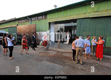 Menschen an der Eröffnung der Galerie Myanmar Licht in einer alten Hafen-Lagerhalle in Yangon, Myanmar, 23. Juli 2014 teilnehmen. Yongon war die Hauptstadt von Myanmar bis 2005. Seit Jahrzehnten die Gebäude verfallen, aber jetzt geben junge Menschen neues Leben in die Stadt. Foto: Philip Heijmans/dpa Stockfoto