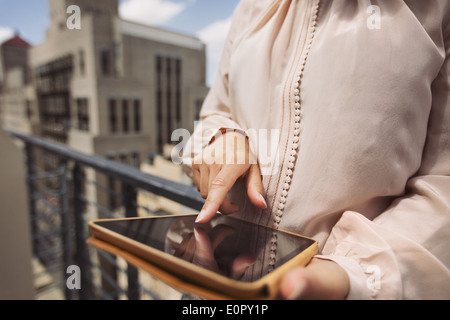 Schließen Sie herauf Bild der jungen Frau auf Balkon mit digital-Tablette. Bild des weiblichen arbeiten auf dem Tablet PC zugeschnitten. Stockfoto