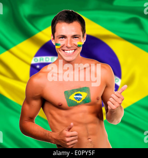 Glücklich brasilianischen Fan feiert Brasilien Flagge Hintergrund Stockfoto