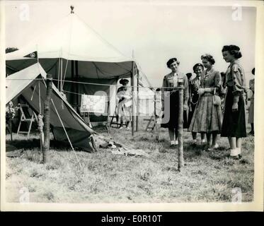 8. August 1957 - besucht Königin Mädchen Führer Welt Camp - Windsor. Geschenk für Prinz Charles und Prinzessin Anne.: HM The Queen besucht die World Camp für Pfadfinderinnen im Windsor Great Park heute. Foto zeigt, wie HM The Queen schaut auf ein Geschenk von einem handgefertigten Zelt - komplett mit Geräte - Besteck - Kochplatten etc., die sie von den britischen Führern als Geschenk für Prinz Charles und Prinzessin Anne - im Camp Vormittag empfing. Stockfoto