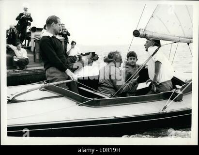 08. Aug. 1957 - Prinz Charles geht mit seinem Vater auf Jachten. Herzog am Tiller an Bord:Prinz Charles begleitet von seinem Vater, dem Herzog von Edinburgh, in der ''Bluebottle'' - als er in einem Drachenklasserennen - während der   heute antritt. Foto zeigt den Herzog an der  mit Prinz Charles und  Fuchs sitzend - und rechts Lieut. Commander A.T. Easton - heute in der ''Bluebottle'' bei Cowes. Stockfoto