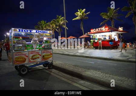 RIO DE JANEIRO, Brasilien - 19. Januar 2014: Mobile Hot-Dog-Wagen steht vor Strandkiosk in einer Abenddämmerung Sonnenuntergang Szene in Ipanema. Stockfoto