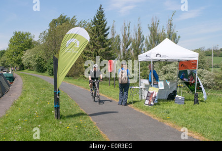 Radfahrer vorbei Stand besetzt von Kanal und Fluss Vertrauen freiwillig neben Leeds und Liverpool canal Barnoldswick, Lancashire, England, Großbritannien Stockfoto