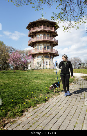 Frau, die ihren Hund durch den Pavillon am Patterson Park, Baltimore, Maryland, USA Stockfoto