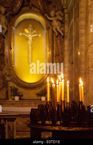 Kerzen vor Jesus Christus am Kreuz, religiöse Symbole von Christentum, Kirche St. Mary Magdalene, Rom, Italien Stockfoto