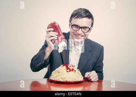 Positiven Konsum Konzept. Glücklich Kaufmann Ketchup auf große Schüssel Nudeln gießen. Stockfoto
