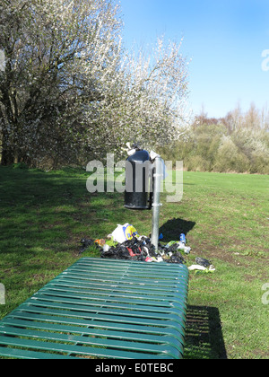 Ungeleerten Abfallbehälter spuckt Müll auf dem Rasen. Stockfoto