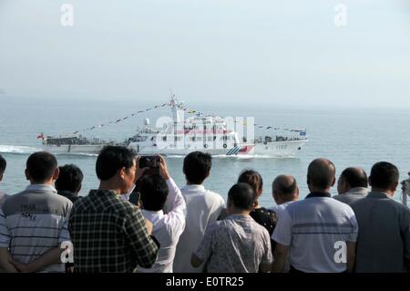 (140520)--an Bord WUZHISHAN, 20. Mai 2014 (Xinhua)--chinesische Staatsbürger an Bord das Passagierschiff Wuzhishan sehen eine chinesische marine Patrouille, als die Wuzhishan Schiff Köpfe nach Haikou, Hauptstadt der Provinz Süd-China Hainan, 20. Mai 2014 ausgeliefert. Die erste Gruppe von Gewalt heimgesuchten chinesische Arbeiter in Vietnam angekommen im Hafen von Haikou am Dienstagmorgen. Die chinesische Regierung schickte vier Schiffe am Sonntag Aufstand heimgesuchten chinesische Arbeiter in Vietnam zu evakuieren, wo schwere Gewalt gegen ausländische Unternehmen seit Mai 13 zwei chinesische Staatsbürger Tote und mehr als 100 Verletzte hinterlassen hat. (X Stockfoto