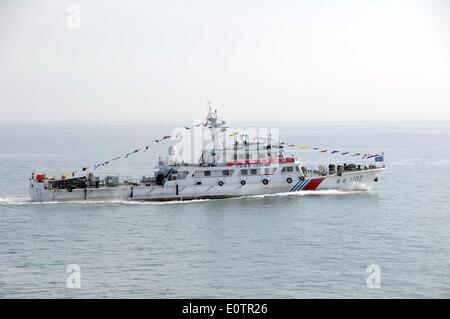 (140520)--an Bord WUZHISHAN, 20. Mai 2014 (Xinhua)--A Chiense marine Patrouillenschiff zeigt ein Banner "Welcome Home" für chinesische Staatsangehörige an Bord das Passagierschiff Wuzhishan als Wuzhishan Schiff Köpfe nach Haikou, der Hauptstadt der Provinz Süd-China Hainan, 20. Mai 2014. Die erste Gruppe von Gewalt heimgesuchten chinesische Arbeiter in Vietnam angekommen im Hafen von Haikou am Dienstagmorgen. Die chinesische Regierung schickte vier Schiffe am Sonntag Aufstand heimgesuchten chinesische Arbeiter in Vietnam zu evakuieren, wo schwere Gewalt gegen ausländische Unternehmen seit Mai 13 zwei chinesische Staatsbürger Toten und vieles mehr hinterlassen hat Stockfoto