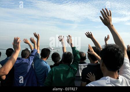 (140520)--an Bord WUZHISHAN, 20. Mai 2014 (Xinhua)--chinesische Staatsbürger an Bord das Passagierschiff Wuzhishan Welle zu einem chinesischen marine Patrouillenschiff als Wuzhishan Schiff Köpfe nach Haikou, der Hauptstadt der Provinz Süd-China Hainan, 20. Mai 2014. Die erste Gruppe von Gewalt heimgesuchten chinesische Arbeiter in Vietnam angekommen im Hafen von Haikou am Dienstagmorgen. Die chinesische Regierung schickte vier Schiffe am Sonntag Aufstand heimgesuchten chinesische Arbeiter in Vietnam zu evakuieren, wo schwere Gewalt gegen ausländische Unternehmen seit Mai 13 zwei chinesische Staatsbürger Tote und mehr als 100 Verletzte hinterlassen hat. Stockfoto