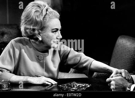 Schauspielerin Joan Crawford an einem Tisch sitzen Stockfoto
