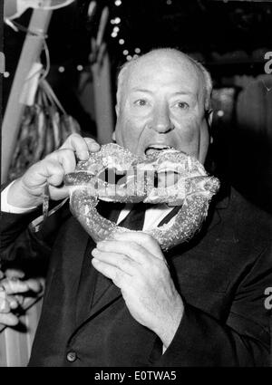 Filmemacher Alfred Hitchcock isst eine Riese Brezel im Oktober Fest Stockfoto