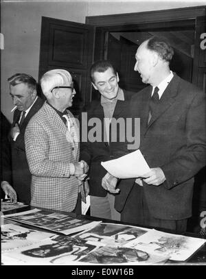 Jean Marais betrachten von Fotos mit Freunden Stockfoto