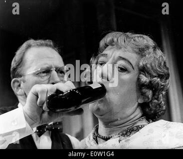 Alec Guinness gekleidet wie eine Frau trinkt Alkohol in einem film Stockfoto