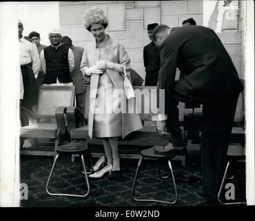 1. Januar 1961 - besucht Königin die SCHREINE von MAHATMA GANDHI. HERZOG PUTS ON SEINE SANDALEN... HM THE QUEEN Smilinjgly blickt auf wie der DUKE OF EDINBURGH zieht seine Schuhe, trägt ein paar Sandalen bei ihrem Besuch in den Schrein von MAHATMA GANDHI am Stadtrand von Neu-Delhi am ersten Tag ihrer indischen Tour... Die Sandalen waren für das Königspaar vorgesehenen Speoially üblich, die Schuhe auszuziehen, wenn Sie den Schrein zu besuchen. Stockfoto