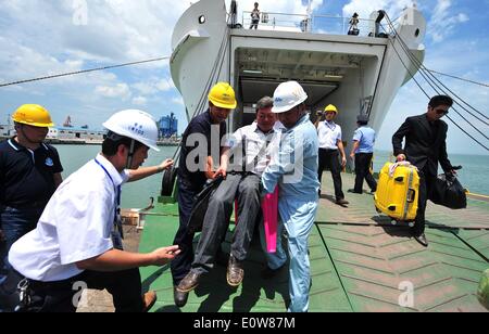 (140520)--HAIKOU, 20. Mai 2014 (Xinhua)--medizinische Arbeiter tragen einen verletzten chinesische Arbeiter, wie sie aus das Passagierschiff Tongguling im Xiuying Hafen in Haikou, der Hauptstadt der Provinz Süd-China Hainan, 20. Mai 2014 von Bord gehen. Gewalt heimgesuchten chinesische Arbeiter in Vietnam kamen am Dienstag im Hafen von Haikou. Die chinesische Regierung schickte vier Schiffe am Sonntag Aufstand heimgesuchten chinesische Arbeiter in Vietnam zu evakuieren, wo schwere Gewalt gegen ausländische Unternehmen seit Mai 13 zwei chinesische Staatsbürger Tote und mehr als 100 Verletzte hinterlassen hat. (Xinhua/Guo Cheng) (Lfj) Stockfoto