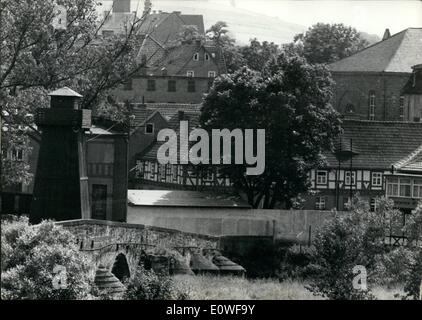 08. August 1962 - Mauern, Stacheldraht und Wachtürme : Schauplatz der Zonengrenze zwischen dem Land Hessen (Westdeutschland) und Thieringen (Ostdeutschland). Ostdeutsche Kommunisten bauten eine Mauer wie die in Berlin an der Ostseite des Werra-Flusses zwischen Phippsthal (Westen) und Vacha (Osten). Ein Teil davon ist mit Parles als ''Sozialismus wird gewinnen'' dekoriert. Von den Wachtürmen auf der Brücke und entlang des Flusses patrouilliert die kommunistische Polizei die Grenze. Stockfoto