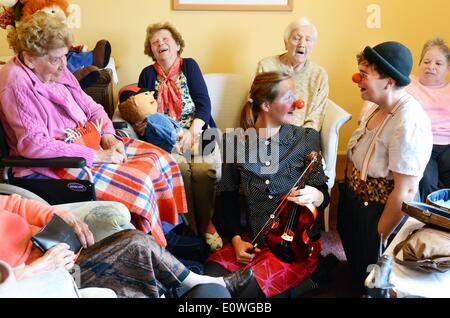 Leipzig, Deutschland. 8. Mai 2014. Heimbewohnern Ruhestand genießen Sie den Besuch der Clowns Sophie Hanses-Ketteler (R) und Maritta Brauer im Altenheim St. Gertrud in Leipzig, Deutschland, 8. Mai 2014. Die Clowns gehören zum Club "Clowns & Clowns", die unter anderem darauf spezialisiert hat, erklingt in Altenheimen. Foto: Waltraud Grubitzsch/Dpa/Alamy Live News Stockfoto