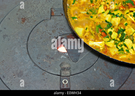 Ein Gemüsegericht auf gusseisernen Holzofen kochen Stockfoto