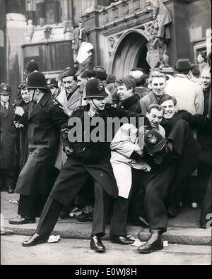 3. März 1963 - protest der Erwerbslosen außerhalb des Unterhauses. Polizist fängt seinen Helm auf seinem Fuß: mehrere tausend Gewerkschafter kam in London heute Morgen und heute Nachmittag marschierten zum House Of Commons mit der Absicht, Lobbyarbeit ihre MP auf die Situation Arbeitslosigkeit in der Industrie. Es gab eine Reihe von Auseinandersetzungen zwischen der Arbeitslosen und der Polizei. Foto zeigt, dass ein Polizist nur schafft es, seinen Helm auf seinem Fuß als mit seinen Kollegen fangen kämpft er wieder die Menge vor der St.-Stephans Eingang des House Of Commons heute Nachmittag zu halten. Stockfoto