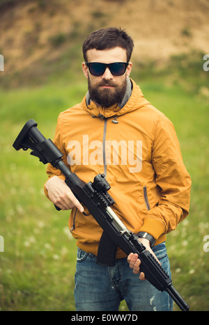 Ein Mann mit einem automatischen Gewehr im freien Stockfoto