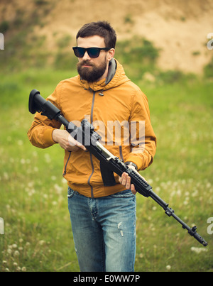 Ein Mann mit einem automatischen Gewehr im freien Stockfoto