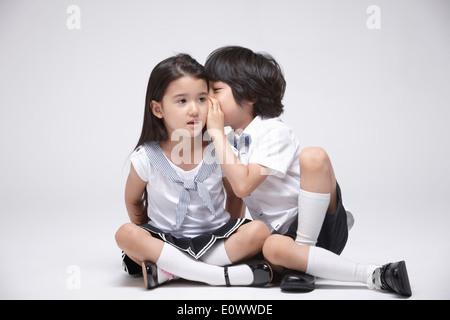 ein Junge und ein Mädchen sitzen nebeneinander Stockfoto