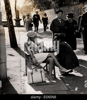 Sep 29, 1964 - London, England, Vereinigtes Königreich - schöne Julie Christie, die für Ruhm mit einer Reihe von Kleinteilen in Filmen - präpariert worden war gestern gesehen ab Werk auf ihre erste Hauptrolle sein. Es ist gegenüber Dirk Bogarde und Laurence Harvey und der Film mit dem Titel "Darling". Die Szene war eine Warteschlange für ein Testspiel außerhalb Lords - in denen sie mit 200 Extras für das Spiel in die Warteschlange. Auf diesem Foto, JULIE CHRISTIE - cap trägt ein rosa Cricket und gestreiften Cricket Blazer - spricht mit DIRK BOGARDE - zwischen Dreharbeiten außerhalb Lords gestern. Stockfoto