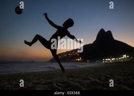 Ein Fußballer erzielt akrobatisch ein Tor aus einem Bicyclette Overhead Fußball Kick am Strand von Ipanema in Rio De Janeiro, Brasilien Stockfoto