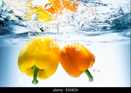 zwei gelbe Paprika ins Wasser fallen Stockfoto