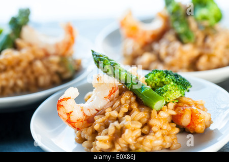 Makro Nahaufnahme von Meeresfrüchte Risottoreis mit Garnelen und grünem Spargel. Stockfoto