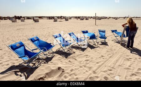 St. Peter-Ording, Deutschland. 20. Mai 2014. Zwei Mitarbeiter von einem Eis lagern Einrichtung Stühle am Strand Nordsee in St. Peter-Ording, Deutschland, 20. Mai 2014. Foto: CARSTEN REHDER/Dpa/Alamy Live News Stockfoto