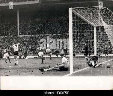 30. Juli 1966 - Fußball-WM. England im Vergleich zu Westdeutschland Weltcup-Finale im Wembley-Stadion. Foto zeigt: England? s Martin Peters (Nr. 16) wirft seine Arme und springt in die Luft, als er England punktet? s zweite Tor während Jagd (Nr. 21) von England überfährt, um ihm zu gratulieren. Durch die Torpfosten ein wenig niedergeschlagen sitzt Schnellinger, der deutschen Außenverteidiger während der deutsche Torwart Hans Tilkowski für den Ball im Netz erreicht. Stockfoto