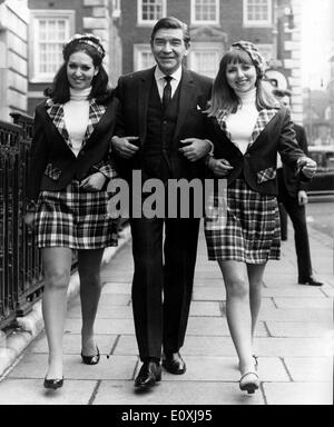 Schauspieler Robert Beatty auf einem Spaziergang mit zwei Modellen in London Stockfoto