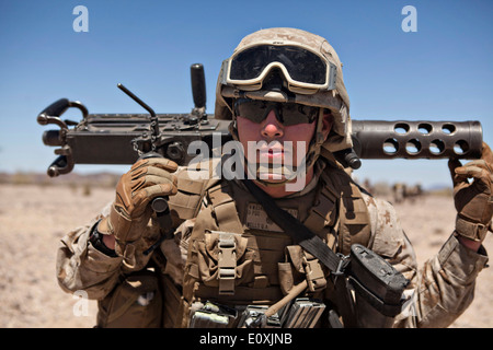 Eine US-Marine MG-Schütze trägt den Lauf ein Kaliber.50-Maschinengewehr Browning M2 beim Angriff Unterstützung Taktik Training auf Yuma Proving Grounds 14. April 2014 in Yuma, Arizona. Stockfoto