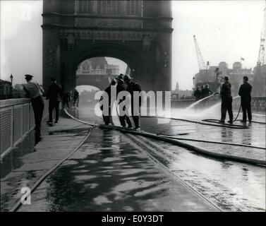 2. Juli 1968 - 2. Juli 1968 Tower Bridge Staus in der Hitze. Londons berühmte Tower Bridge war gestern durch die Hitze betroffen. Es wurde eröffnet, um ein Schiff durchzulassen. Das Metall erweitert mehrere Zoll und eine, die die Wappen der Brücke nicht einrastet stecken würde. Die Brücke war für zwei Stunden während der Hauptverkehrszeit gestern Abend für den Verkehr gesperrt, da Feuerwehrmänner Schläuche auf dem Blech abkühlen es gespielt. Foto zeigt: Feuerwehrmänner Schläuche auf der Brücke zu spielen es gestern abkühlen lassen. Stockfoto