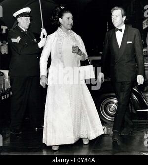 15. April 1969 - Royal Theater besuchen: Prinzessin Margaret, geschützt von Starkregen von einem großen Sonnenschirm, galant von einem Türsteher, gehalten am Prince Of Wales Theatre mit Lord Snowdon (rechts), für eine Benefiz-Veranstaltung der Komödie '' Katze unter den Tauben '' kommt. Die Aufführung war zugunsten der National Youth Theatre, von denen Lord Snowdon Schirmherr ist. Stockfoto