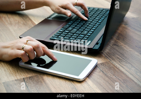Frau mit Tablet und Laptop auf hölzernen Hintergrund Stockfoto