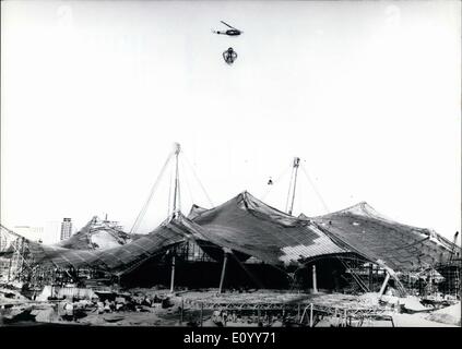 11. November 1971 - Topping-Up Zeremonie auf die Olympischen Gebäude Sitw in München: 10 Monate vor der geplanten Eröffnung der Olympischen Spiele 1972, die Arbeiter auf der Baustelle heute feierte die Fertigstellung der gigantischen Dach des Stadions. Ein Hubschrauber hebt die speziell angefertigte '' Krone '' aus Stahl und Girlanden auf das Dach. Danach wurden die internationale Arbeitskräfte von 5000 Männern Freibier und Erfrischungen behandelt. Stockfoto