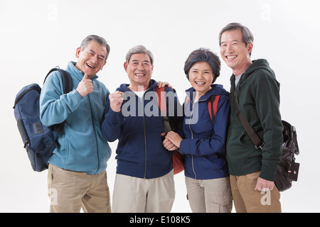 drei alte Männer und eine alte Frau trägt einen Rucksack Stockfoto