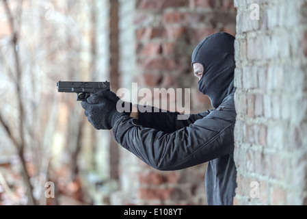 Mann mit Maske mit Pistole Stockfoto