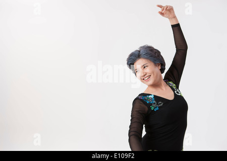 eine alte Frau in einem schwarzen Kleid machen Tanz Posen Stockfoto