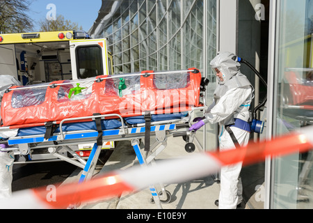 Biohazard-medizinische Team-Mitglied mit Bahre Eingabe kontaminierte Gebäude Stockfoto