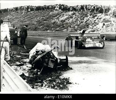 30. Juli 1973 - britische Rennfahrer in Holländisches großartiges Prix getötet: 25 Jahre alte britische Automobilrennfahrer Roger Williamson starb gestern als er in seinem Rennwagen gefangen, war die nach abseits der Spinnen und Absturz bei 120 mph, während die niederländischen Grand Prix auf der Rennstrecke von Zandvoort Feuer gefangen. Das Foto zeigt Jakie Stewart, der gewann das Rennen, vorbei an den Trümmern des Autos, in denen Roger Williamson, während der gestrigen Holländisches großartiges Prix gestorben, zu sehen. Stockfoto