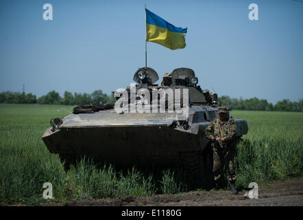 Donezk, Ukraine. 21. Mai 2014. Ein Soldat steht Wache neben einer bewaffneten Fahrzeug an einem Kontrollpunkt in der Nähe von Donetsk, Ukraine, 21. Mai 2014. Etwa 800 Soldaten der Ukraine haben mehrere Kontrollpunkte um Donezk eingerichtet, um die Straße von Donezk an der Grenze zu Russland am Mittwoch zu sichern. Das ukrainische Außenministerium am Mittwoch forderte Russland seine Bemühungen, die Krise in der Ostukraine verstärken. Bildnachweis: Dai Tianfang/Xinhua/Alamy Live-Nachrichten Stockfoto