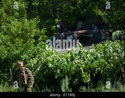 Donezk, Ukraine. 21. Mai 2014. Ein Soldat steht in der Nähe von einem bewaffneten Fahrzeug an einem Kontrollpunkt in der Nähe von Donetsk, Ukraine, 21. Mai 2014. Etwa 800 Soldaten der Ukraine haben mehrere Kontrollpunkte um Donezk eingerichtet, um die Straße von Donezk an der Grenze zu Russland am Mittwoch zu sichern. Das ukrainische Außenministerium am Mittwoch forderte Russland seine Bemühungen, die Krise in der Ostukraine verstärken. Bildnachweis: Dai Tianfang/Xinhua/Alamy Live-Nachrichten Stockfoto